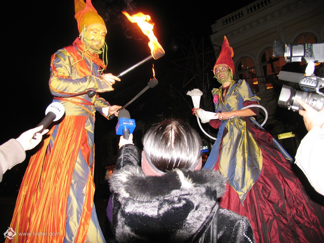 actors at stilts interact with a journalists